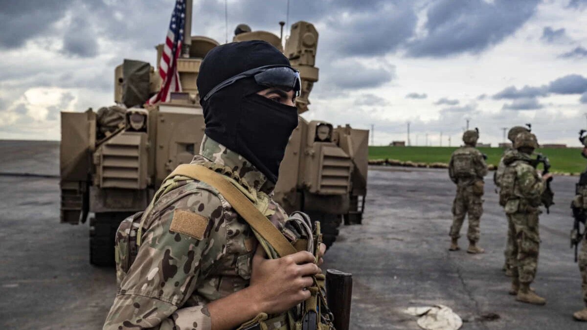 Un membre des Forces démocratiques syriennes se trouve près d’un véhicule militaire blindé à la périphérie de Rumaylan, dans la province de Hassaké (nord-est de la Syrie), le 27 mars 2023 (AFP)