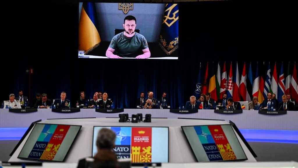 Ukraine's President Volodymyr Zelensky appears on a giant screen as addresses a Nato summit in Madrid, 29 June 2022 (AFP)