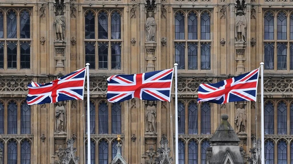 Union flags flutter outside the Palace of Westminster in central London on 25 March 2021 (AFP)