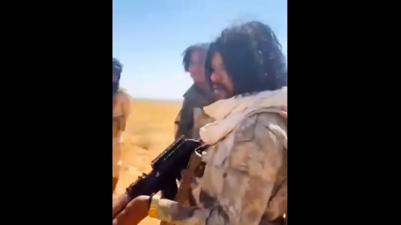 A man who appears to be RSF commander Abu Lulu points a gun at detained men before shooting them (social media)