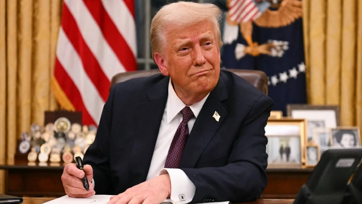 US President Donald Trump signs executive orders in the Oval Office of the White House in Washington DC, on 20 January 2025 (AFP)