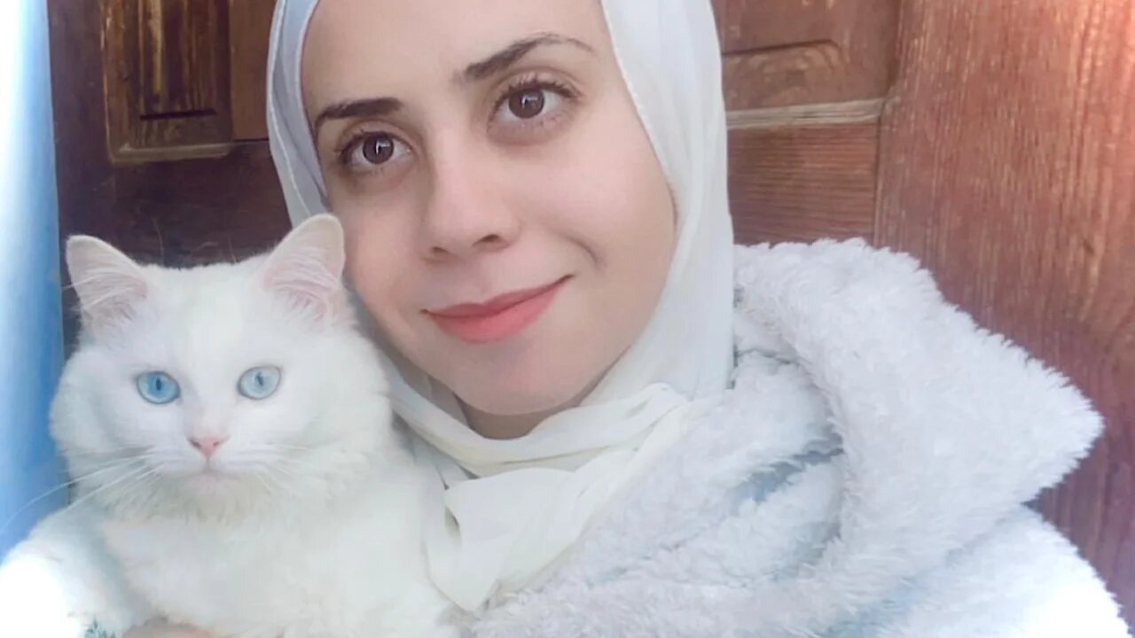 The author poses for a selfie with her cat Beasty as they seek shelter at a relative's home in April 2024 (Tarneem Hammad)