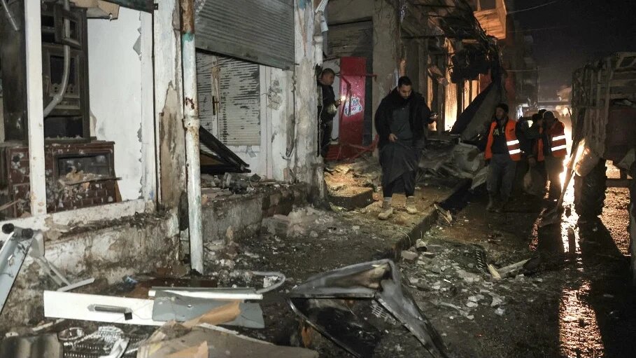 Workers clear rubble after a Syrian army bombardment in Idlib on 9 December 2023 (AFP)