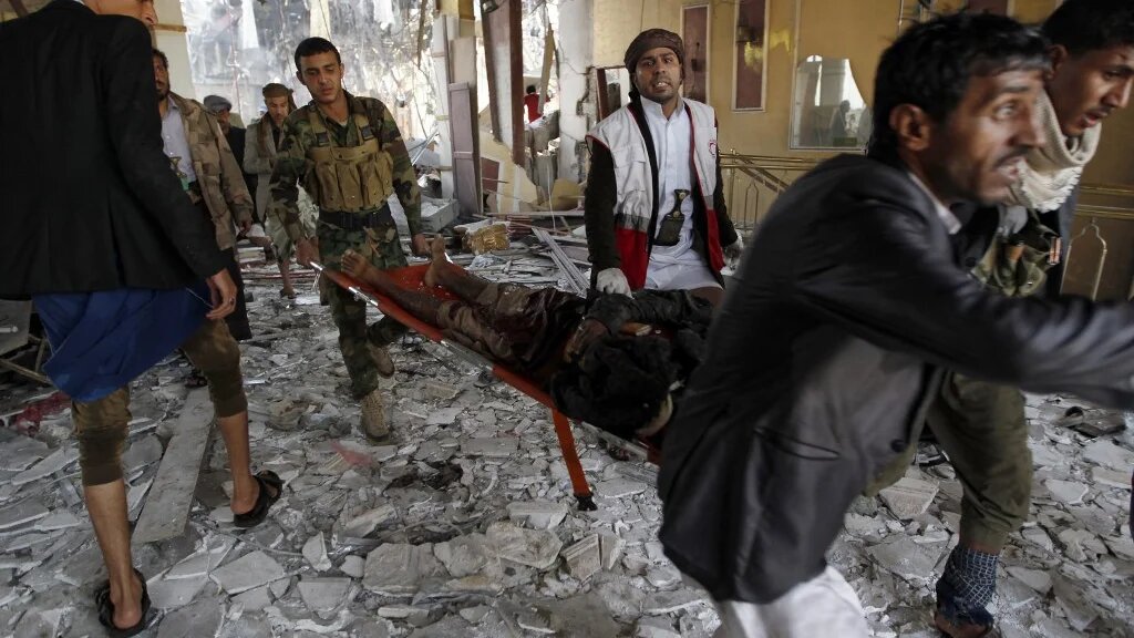 Yemeni rescue workers carry a victim on a stretcher amid the rubble of a funeral hall hit by Saudi-led coalition airplanes in Sanaa on 8 October 2016 (AFP)