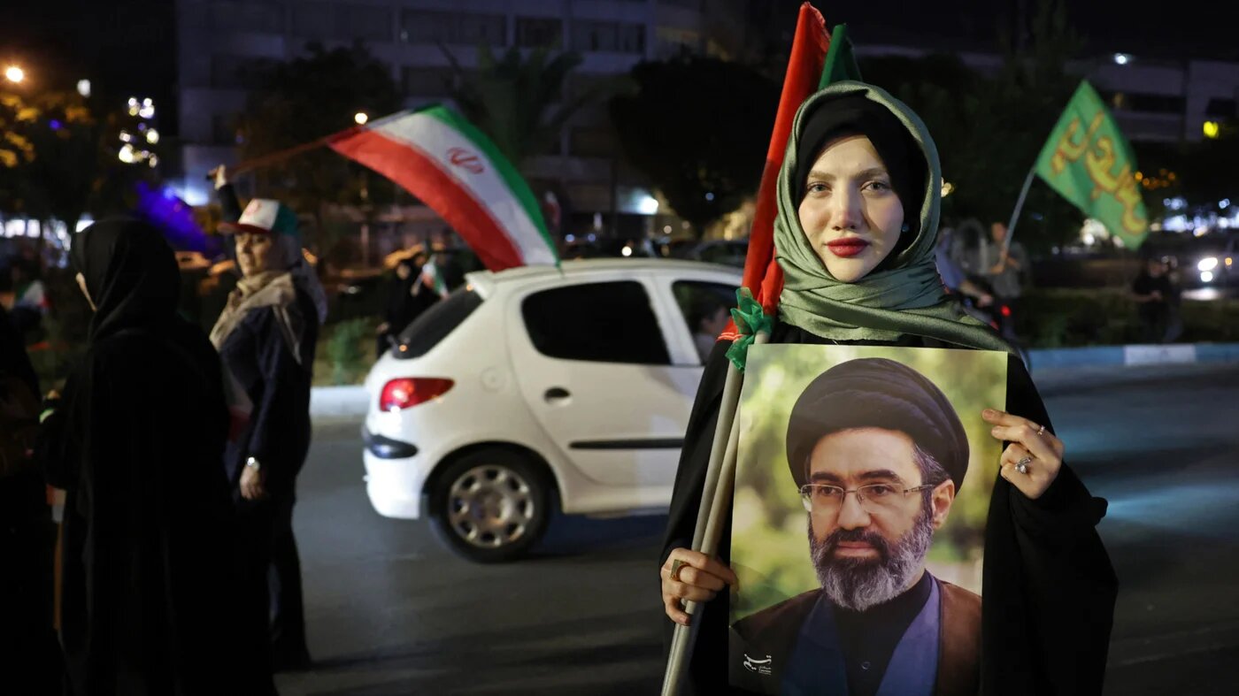A woman holds a portrait of Iran's supreme leader Ayatollah Mojtaba Khamenei during a rally against the US and Israel in Tehran on 29 May 2026 (AFP)