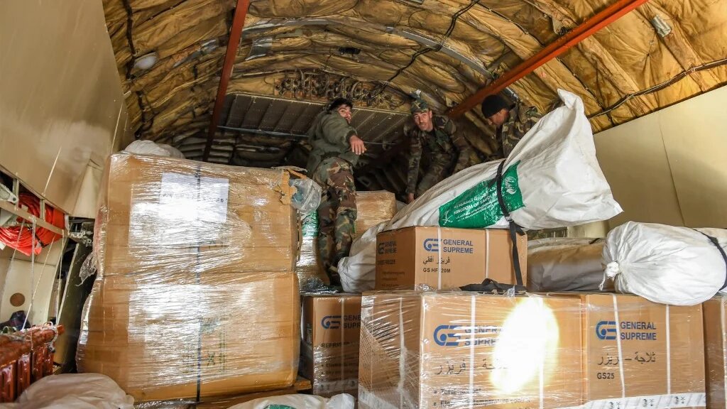 Des colis humanitaires fournis par l’Arabie saoudite, destinés aux victimes du séisme au nord de la Syrie, sont chargés à bord d’un avion à l’aéroport d’Alep, le 14 février 2023 (AFP)