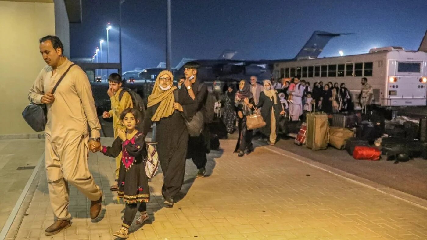 Des personnes évacuées d’Afghanistan arrivent à la base aérienne d’al-Udeid au Qatar, le 21 août 2021 (Bureau de communication du gouvernement qatari/AFP)