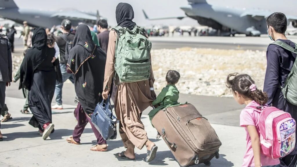 Afghan civilians head towards an aircraft during an evacuation at Hamid Karzai International Airport, Kabul, Afghanistan, on 24 August 2021.