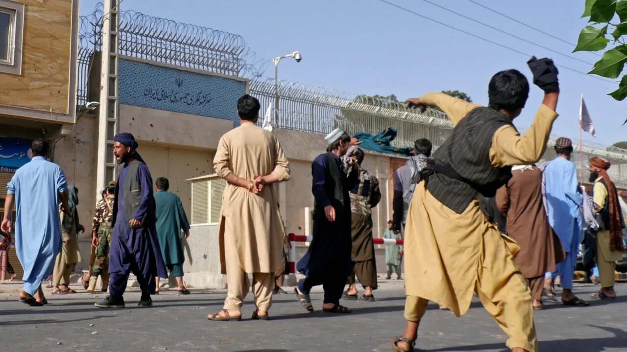 Afghan protesters throw stones at the Iranian consulate in Herat on on 11 April 2022 during a demonstration over reports of harassment of Afghan refugees in Iran (AFP)