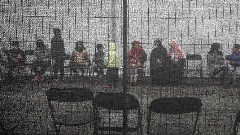 Afghan refugees queue outside a distribution and donation center at Liberty Village on 2 December 2021 in Joint Base McGuire-Dix-Lakehurst, New Jersey.