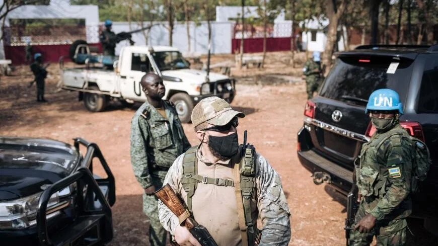 Un Casque bleu de l’ONU aux côtés d’un combattant russe et d’un membre de la garde présidentielle du président centrafricain Faustin-Archange Touadéra à Bangui, le 27 décembre 2020 (AFP)