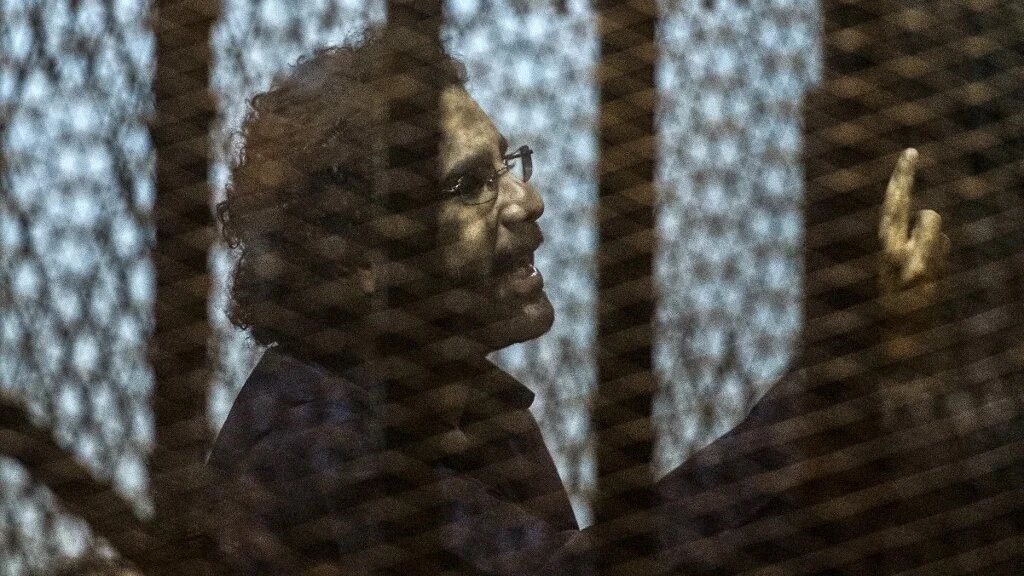 Egyptian activist Alaa Abd El-Fattah gestures from the defendant’s cage during his trial in Cairo in May 2015 (AFP)