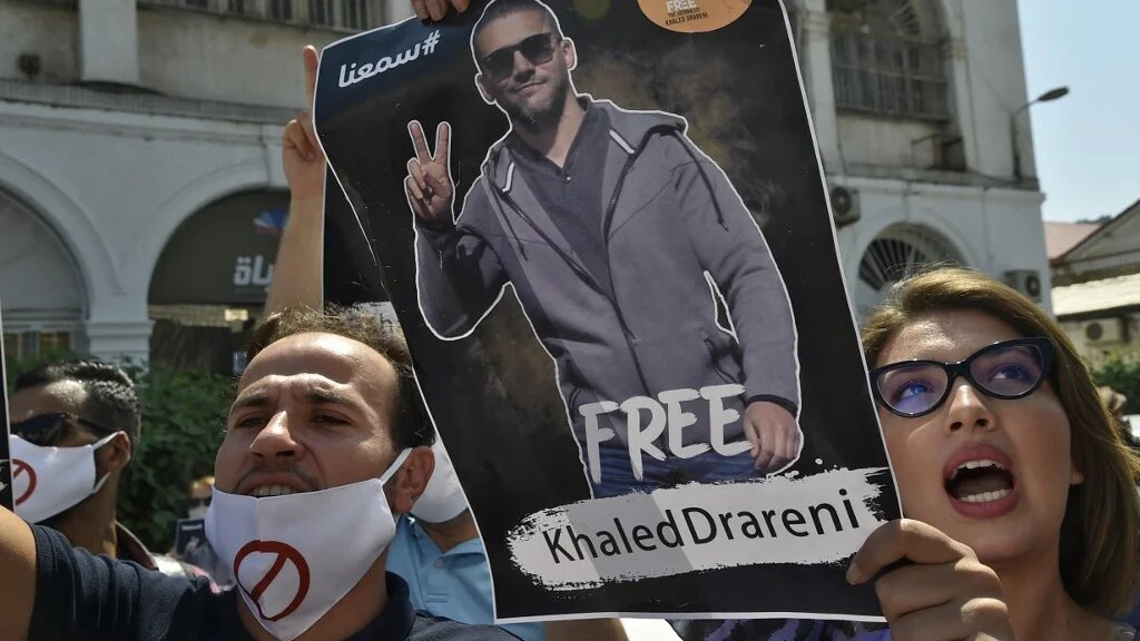 Algerians lift a portrait of journalist Khaled Drareni during a rally to protest his incarceration in the capital Algiers, on 7 September 2020.