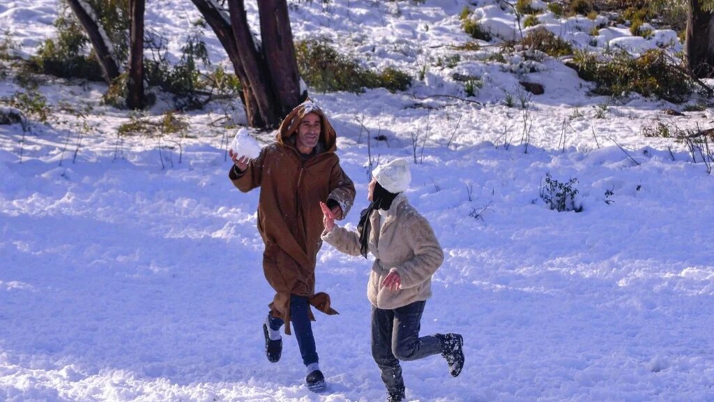 Des Algériens jouent dans la neige à Constantine, dans l’est de l’Algérie, le 23 janvier 2023 (AFP)