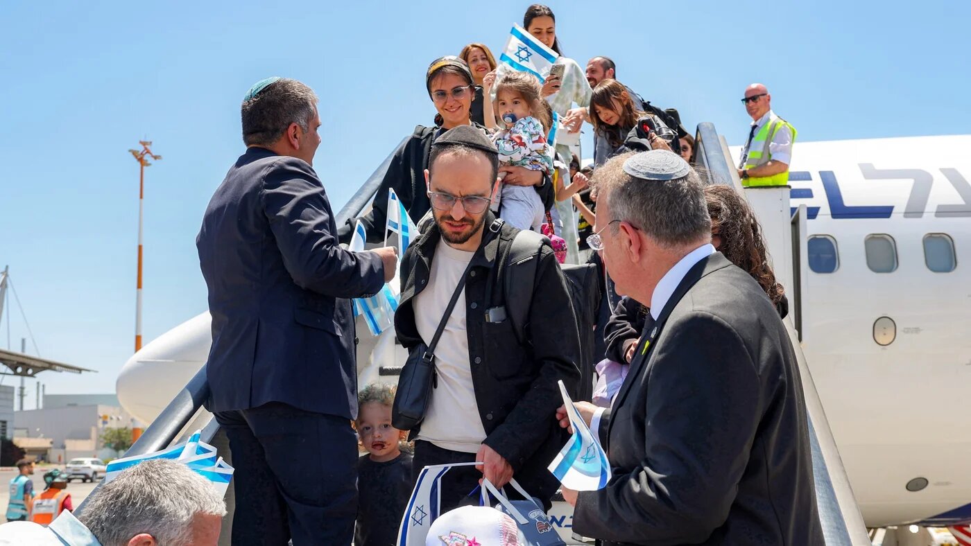 Yaakov Hagoel (R), chairman of the World Zionist Organisation, receives Jewish migrants making Aliyah (immigration to Israel) upon disembarking from an Israeli El Al airlines aircraft after their arrival at Ben Gurion Airport in Lod on June 25, 2025. Jack GUEZ / AFP