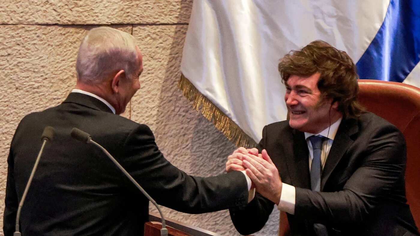 Israel's prime minister, Benjamin Netanyahu (left), shakes hands with Argentina's president, Javier Milei (right), at the Israeli parliament on 11 June 2025 (Menahem Kahana/AFP)