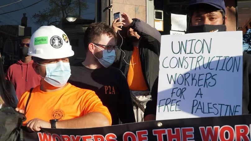 Construction workers hold banners during a protest for Palestine organised by Within Our Lifetime in the Bronx, a borough in New York City.