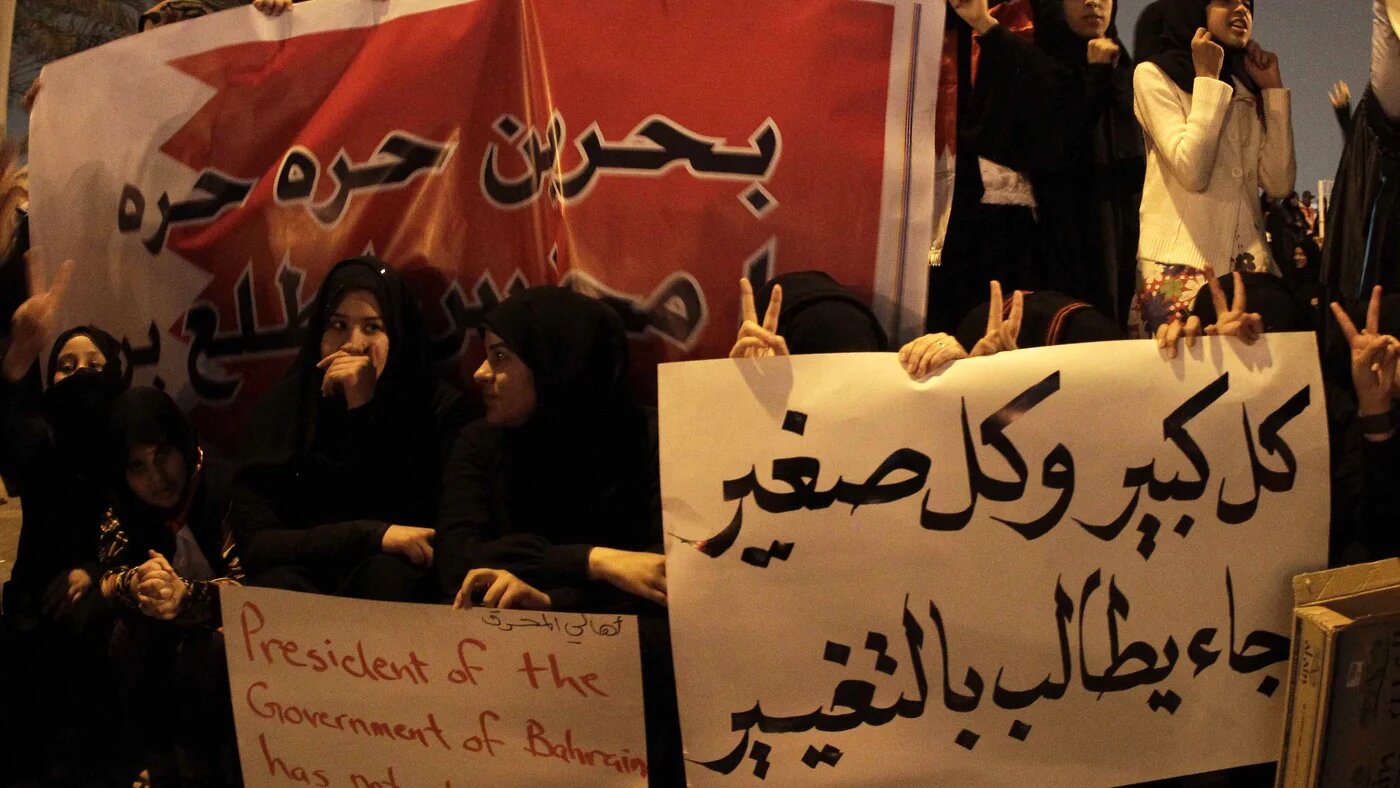 Bahraini anti-government protesters hold signs calling for freedom and change as they gather at Pearl Square in Manama on 16 February 2011.