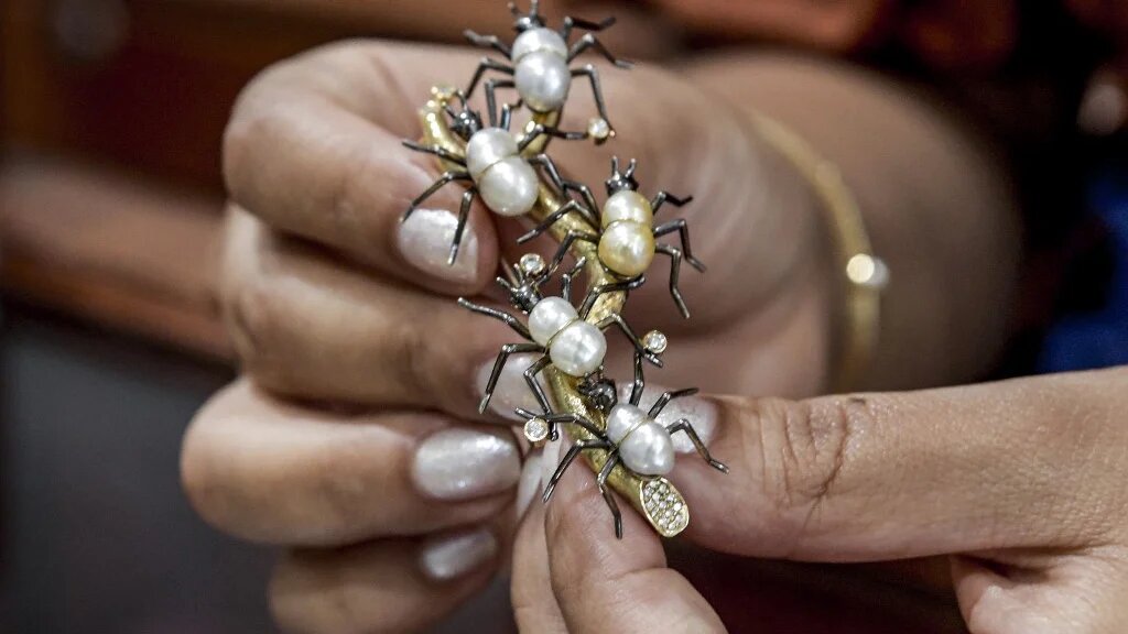 Une broche incrustée de petites perles similaires et pourtant toutes « uniques » (AFP/Mazen Mahdi)