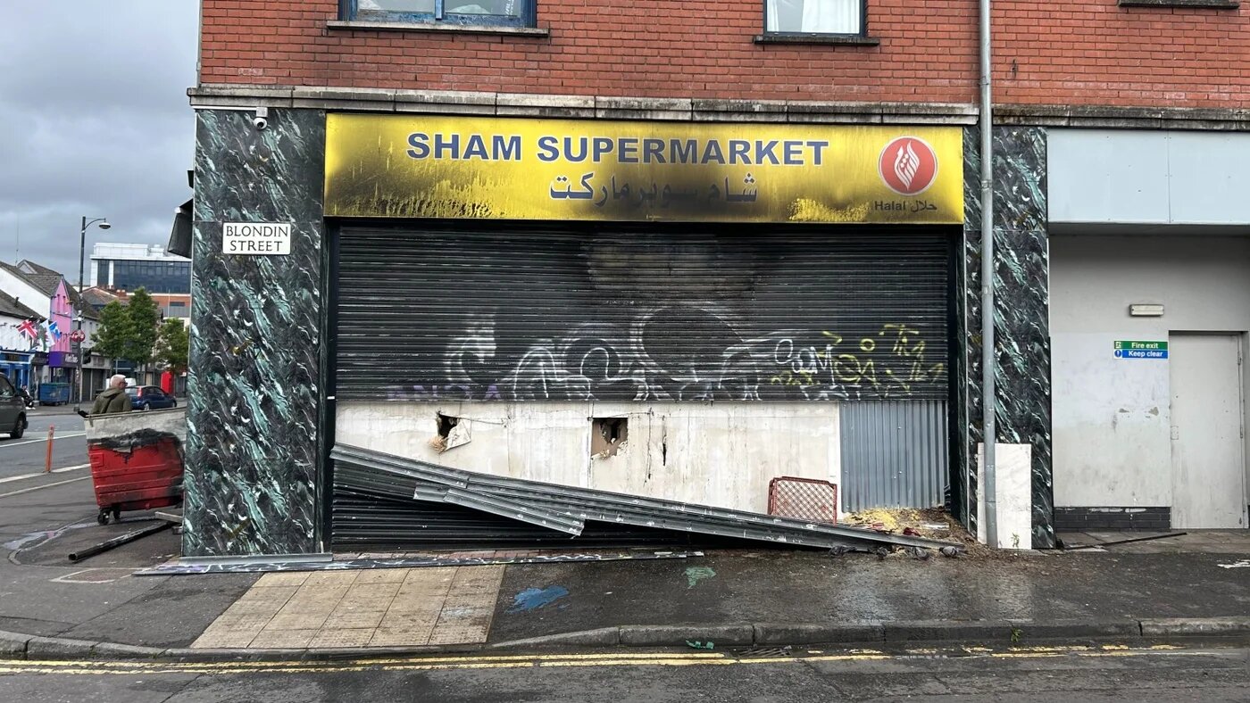 The Sham supermarket in Belfast after it was set fire to by gangs of masked men this week (Oscar Rickett/MEE)