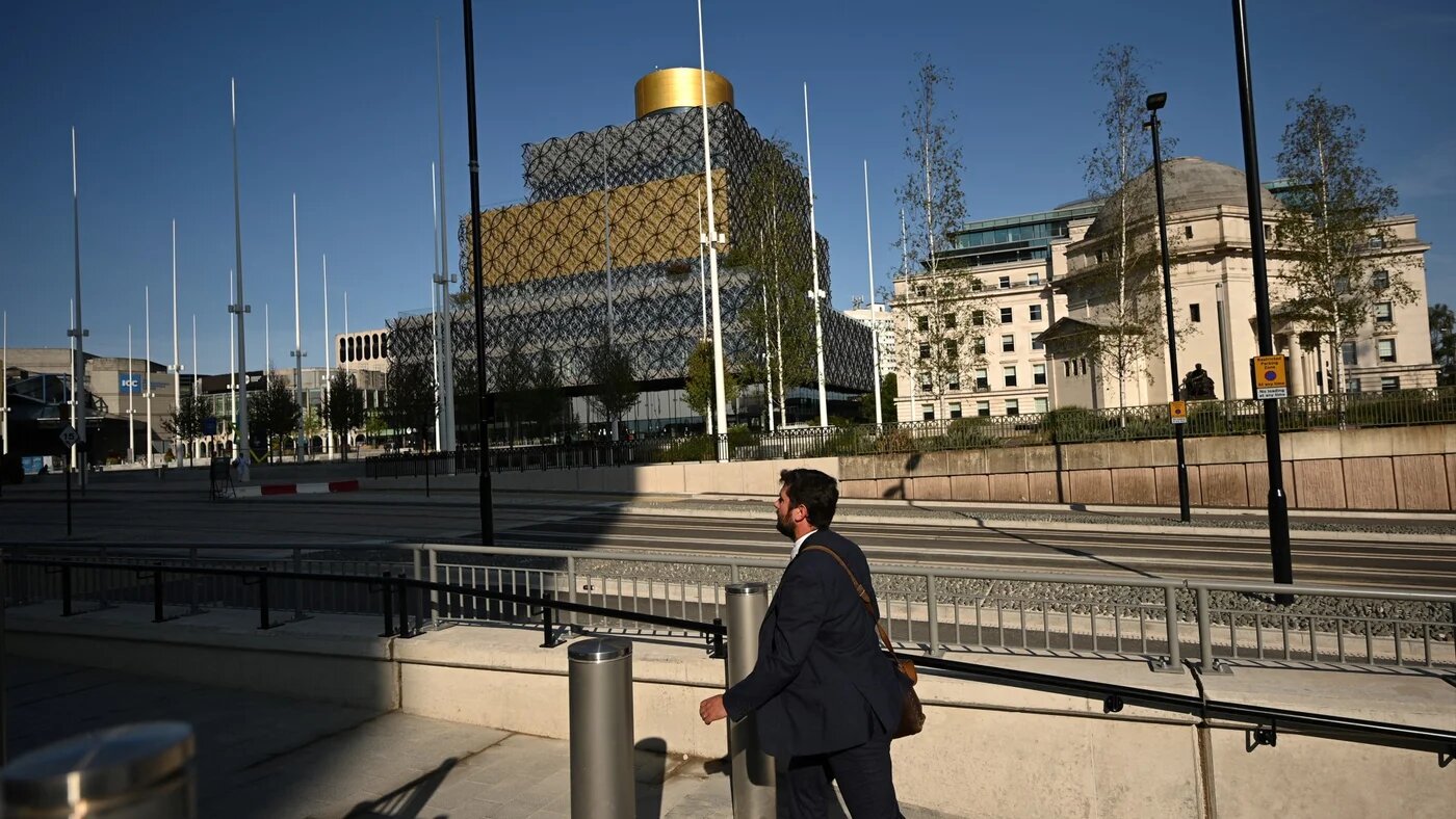 A pedestrian walks along an almost empty street in Birmingham, central England, on 14 September 2020 (AFP/Oli Scarff)