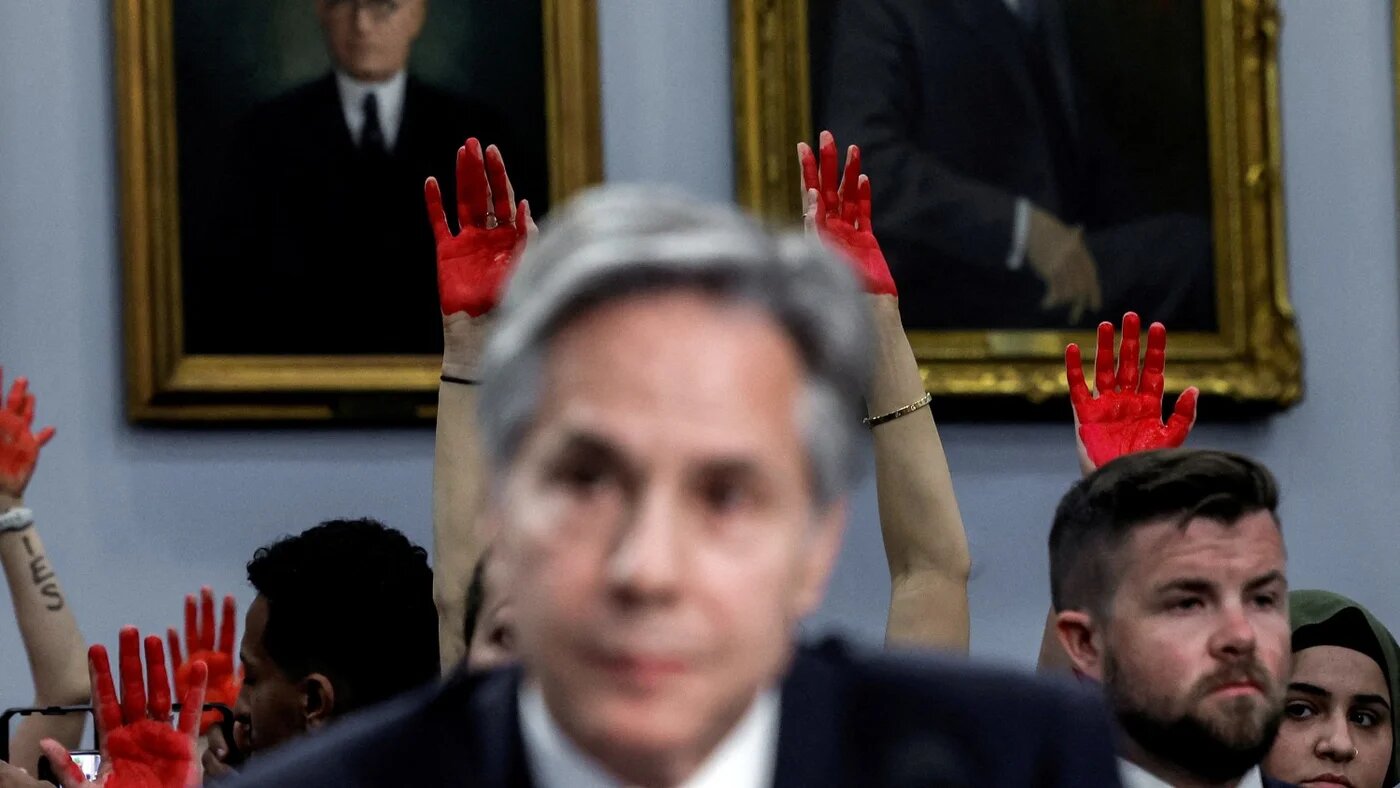 Pro-Palestinian protesters hold up red hands as US Secretary of State Antony Blinken testifies before a congressional hearing in Washington DC on 22 May 2024.