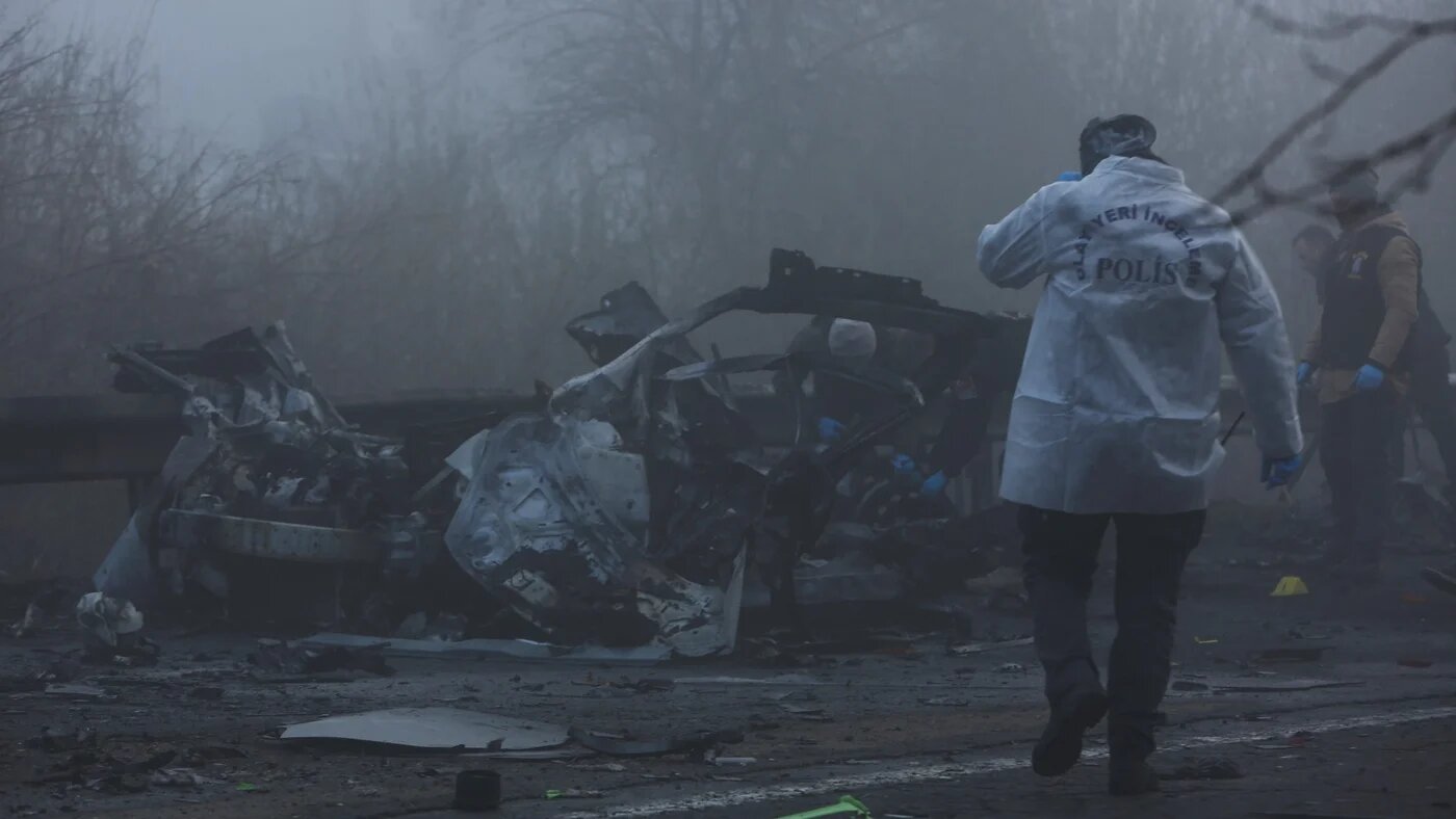 Police forensic experts examine the site after a bomb exploded in a roadside vehicle while a police minibus passed by in Diyarbakir, Turkey on 16 December 2022 (Reuters)