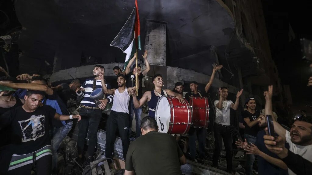 Palestinians celebrate in the street following a ceasefire agreement between Hamas and Israel.