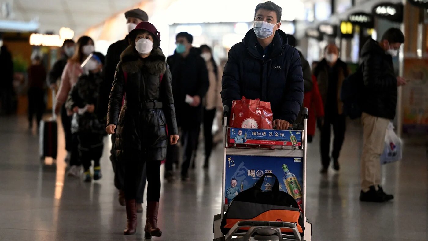 Passengers walk through a departure terminal of the international airport in Beijing on 29 December 2022 (AFP)