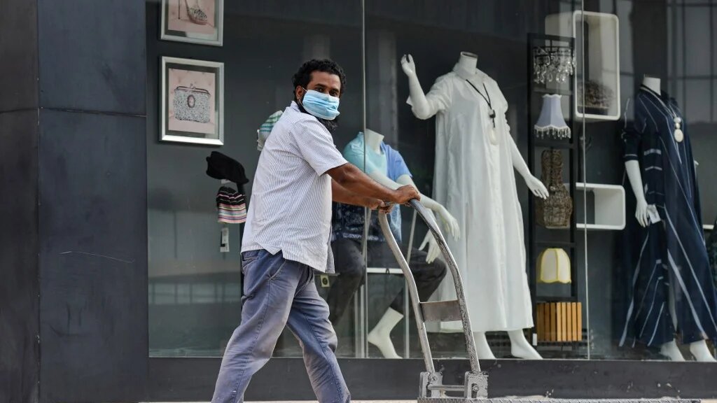 A Saudi worker wearing a mask passes a boutique shop. Riyadh reported more than 200,000 novel coronavirus cases.