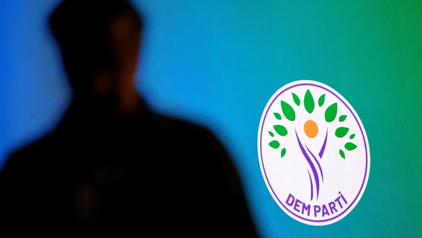 A man stands in front of the Dem party logo during the International Conference on Peace and Democratic Society in Istanbul, on 6 December 2025 (Yasin Akgul/AFP)