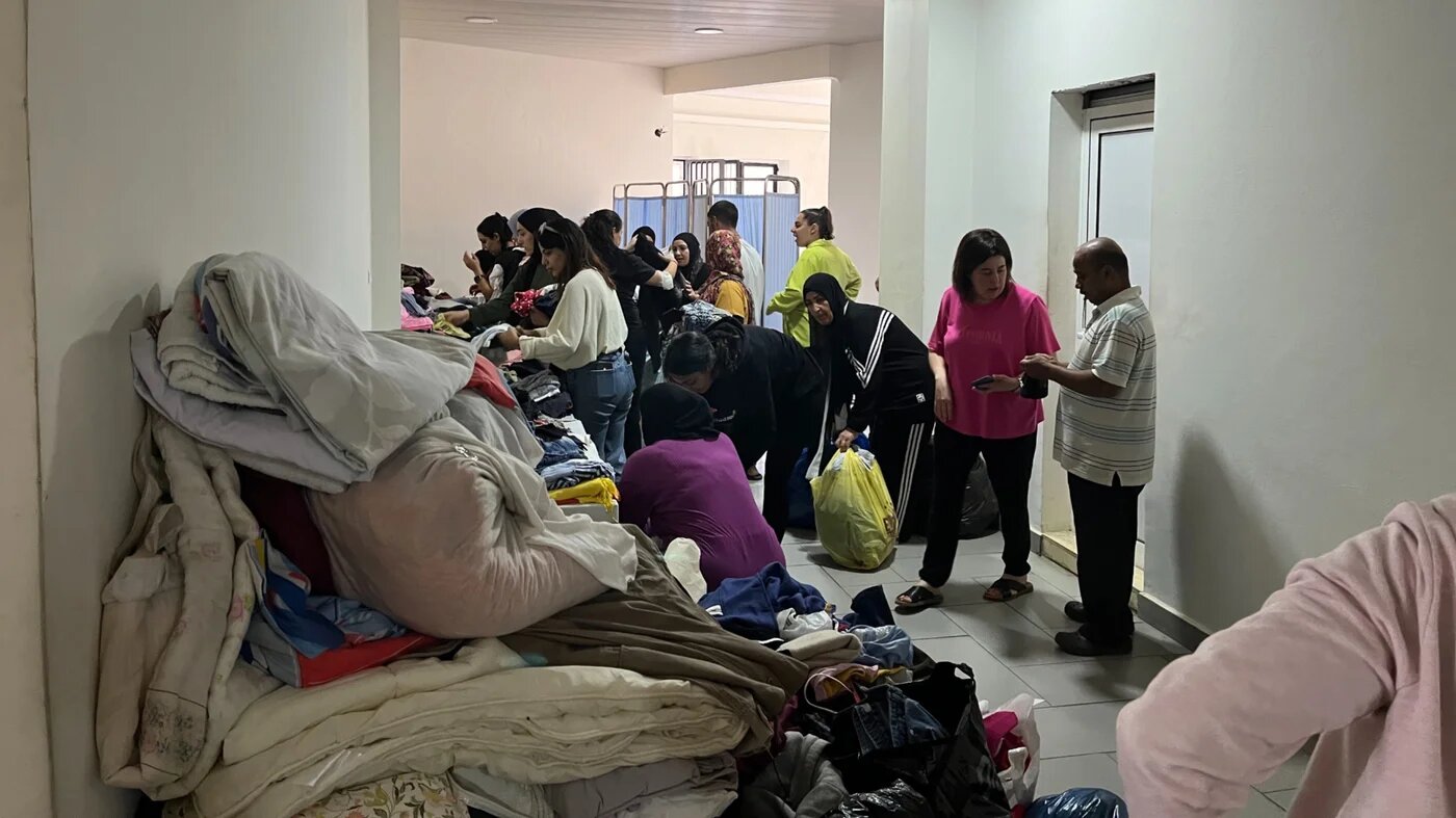 Displaced Lebanese people receive aid in Dhour el-Choueir's municipality building on 26 September 2024 (Nader Durgham/MEE)