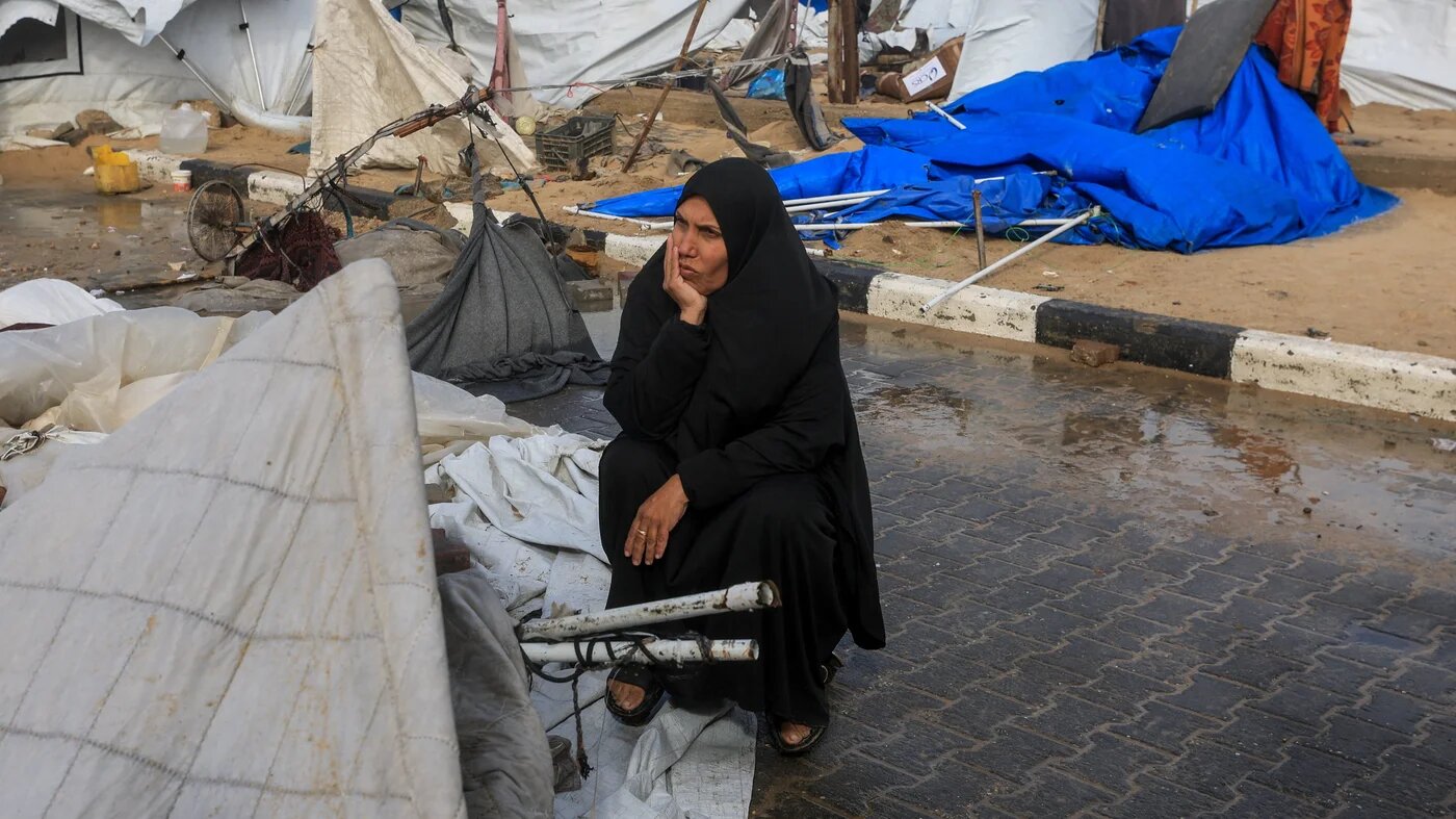 A displaced Palestinian woman sits near damaged tents, amid violent storms in Gaza City, 13 January, 2026 (ReutersDawoud Abu Alkas)