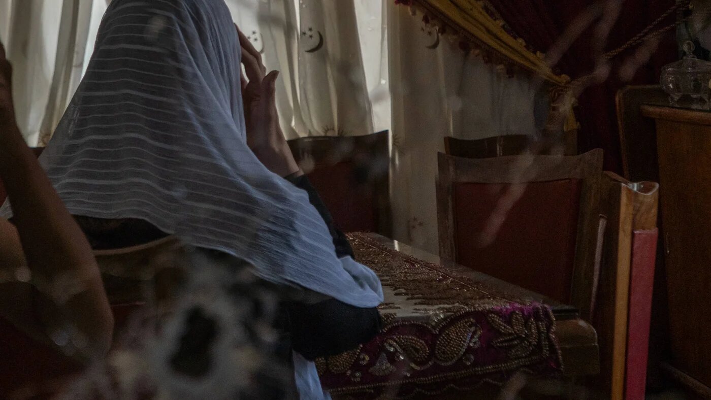 Deema Saraya sits in her house in front of a mirror cracked by a bullet. Her husband was executed, she was a hostage for around eight hours (Anagha Subhash Nair/MEE)