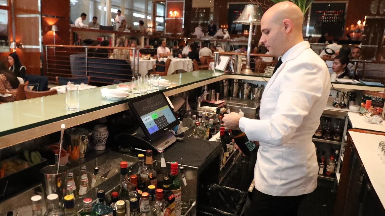A bar tendant serves customers at a restaurant in Dubai on 30 August 2018.