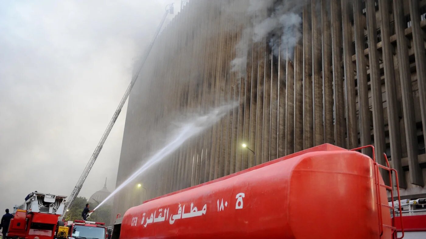 Firefighters douse the flames after a fire broke out in the Telephones landline exchanging station and Ministry of Communications building in the heart of Cairo on 7 July 2025 (AFP)