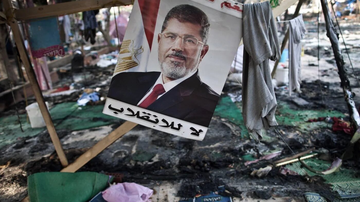 Affiche de Mohamed Morsi dans un camp de ses partisans détruit par l’armée lors du massacre de la place Rabia, en août 2013 (AFP)