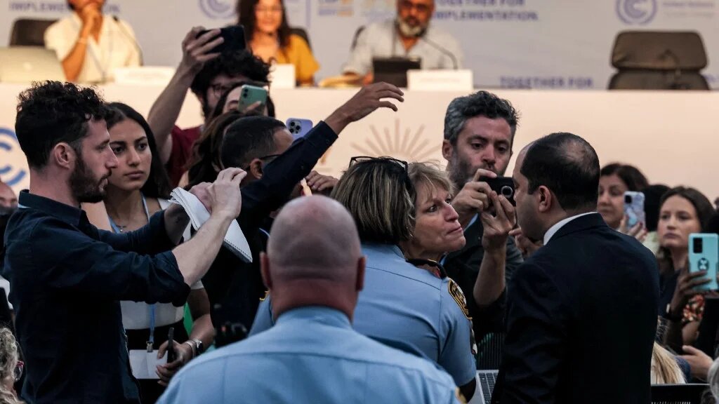 Attendees argue with Egyptian MP Amr Darwish as he interrupts a press conference attended by Sanaa Seif, sister of Alaa Abdel Fattah, on the sidelines of Cop27, 8 November 2022 (AFP)