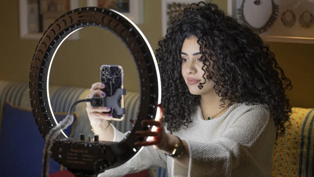 Mariam Ashraf, enseignante et « influenceuse des cheveux naturels », fait un direct chez elle au Caire, le 22 mars 2022 (AFP/Khaled Desouki)