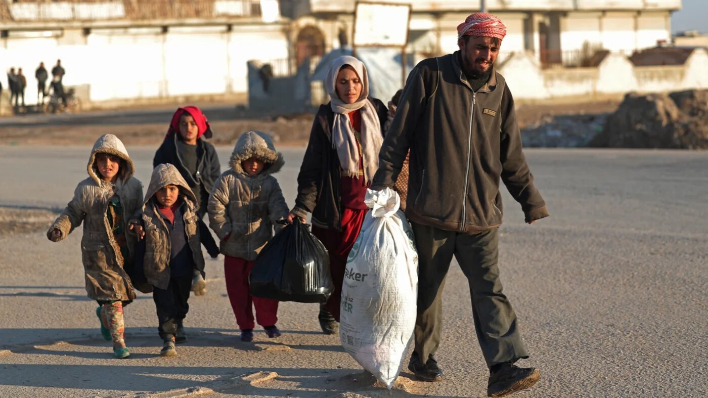 A family flees from the vicinity of the Humaymah village, east of Aleppo city, as civilians fled a Kurdish-held region of northern Syria on January 16, 2026 (AFP)