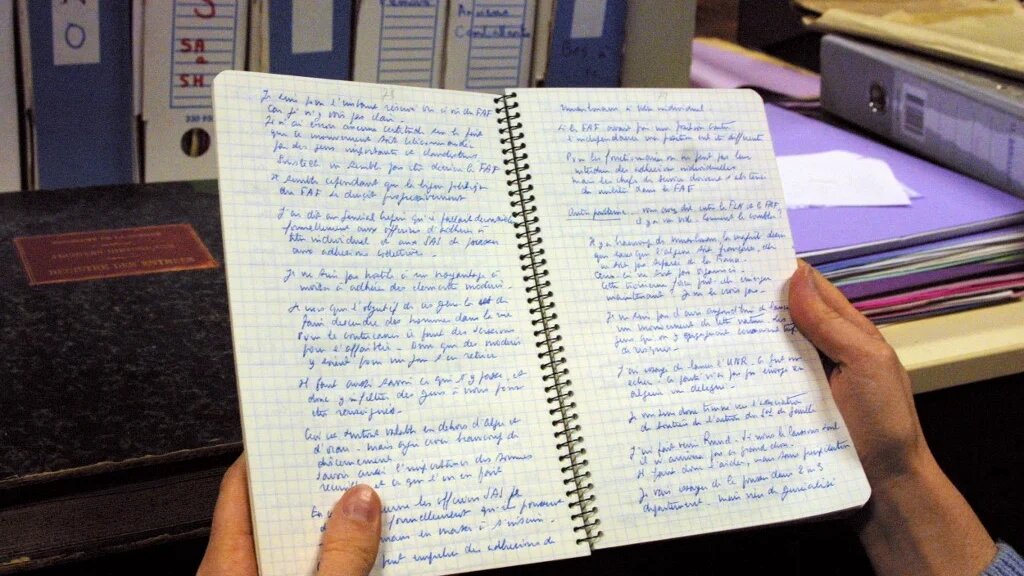 Une personne consulte, le 29 octobre 2001, dans une salle du Service historique de l’armée de terre au château de Vincennes, un des carnets de notes écrits pendant la guerre d’Algérie par le préfet Jean Vaujour, directeur de la sûreté générale en Algérie au début du conflit (AFP/Daniel Janin)