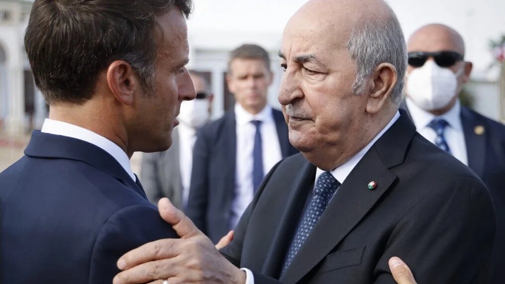 Le président français Emmanuel Macron (à gauche) salue le président algérien Abdelmadjid Tebboune (à droite) à son arrivée à l'aéroport d’Alger, le 27 août 2022 (AFP/Ludovic Marin)