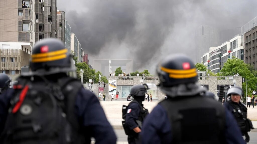 Des CRS font face à des manifestants dans le quartier de La Défense à Paris à l’issue d’une marche de commémoration pour Nahel, adolescent abattu par un policier le 27 juin 2023 à Nanterre, en banlieue parisienne, deux jours après sa mort (AFP/Zakaria Abdelkafi)