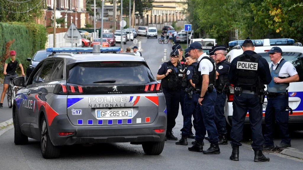 Des policiers se tiennent dans une rue où se trouve une maison appartenant à la famille de l’imam Hassan Iquioussen, à Lourches, dans le nord de la France, le 30 août 2022 (AFP/François Lo Presti)
