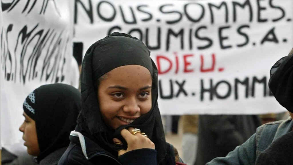 Une jeune fille voilée manifeste devant l’hôtel de ville de Toulouse, le 17 janvier 2004, lors d’un rassemblement silencieux regroupant plus d’une centaine de personnes, pour la plupart des femmes, pour protester contre le projet de loi interdisant le port du voile islamique à l’école (AFP/Éric Cabanis)