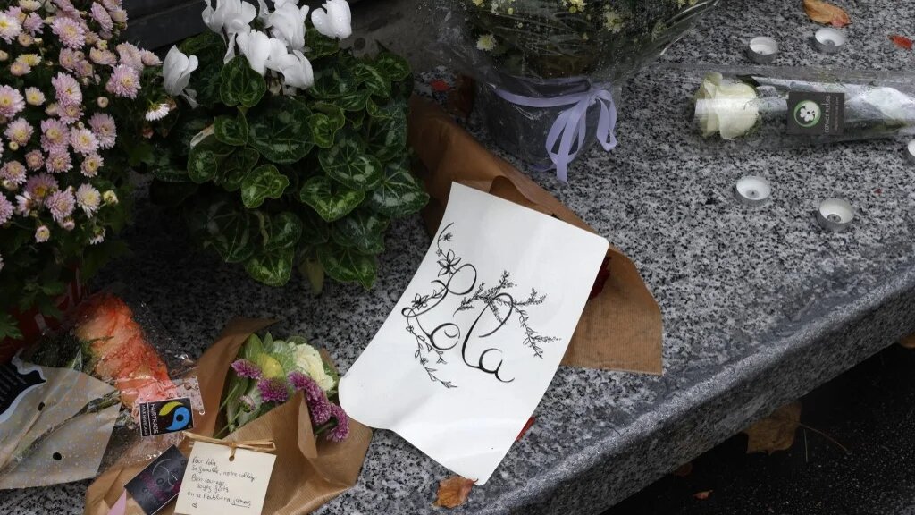 Des fleurs exposées devant le collège Georges Brassens à Paris le 17 octobre 2022, où étudiait Lola, 12 ans, trois jours après la découverte de son corps dans une malle (AFP/Geoffroy Van der Hasselt)