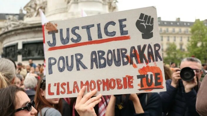 A protester holds a sign reading “Justice for Aboubakar, Islamophobia kills” during a gathering in tribute to Aboubakar Cisse in Paris on 27 April 2025 (Alain Jocard/AFP)
