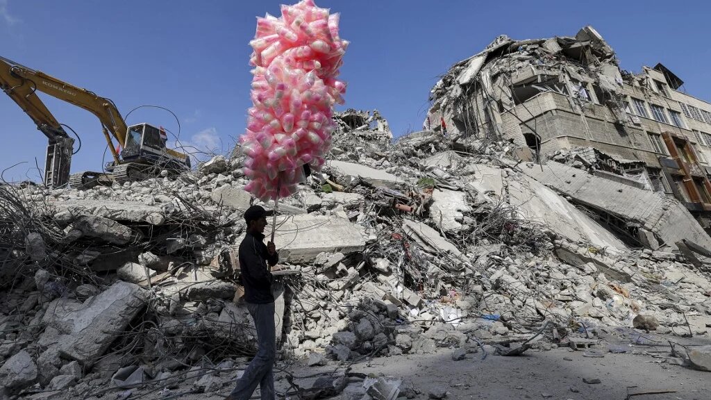 A Palestinian walks past the rubble of a building destroyed during the Israeli offensive on Gaza on 10 June 2021.