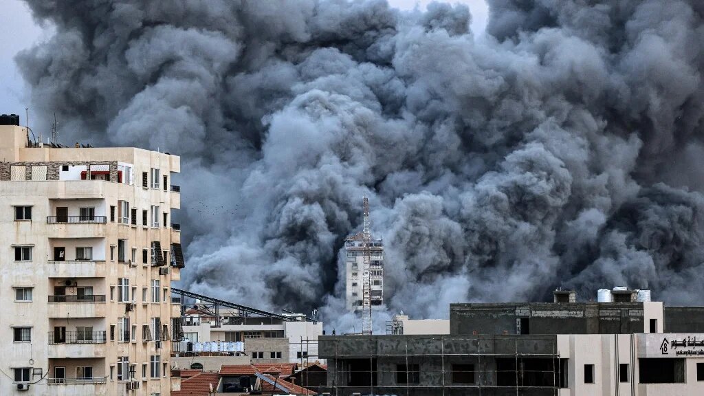 Une colonne de fumée s’élève au-dessus des bâtiments de Gaza, le 7 octobre 2023, lors d’une frappe aérienne israélienne (AFP/Mahmud Hams)