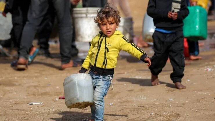A child carries a water container in Gaza’s Maghazi camp on 11 February 2026 (Eyad Baba/AFP)
